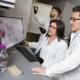 Three Georgia Tech researchers working together in the lab on cancer research